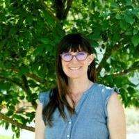 Photo of Amy May in blue shirt and red glasses Photo of Amy May in blue shirt and red glasses