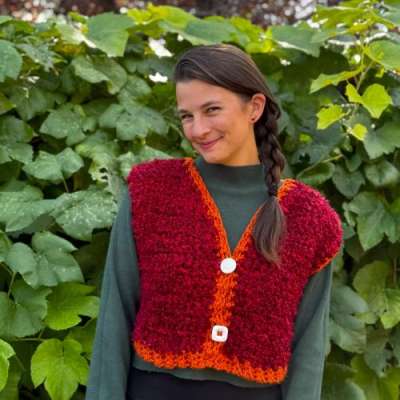 Kat wearing a red knit vest with nature in the background. Kat wearing a red knit vest with nature in the background.