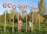 Two people stand beneath the sculptural EcoGarden sign